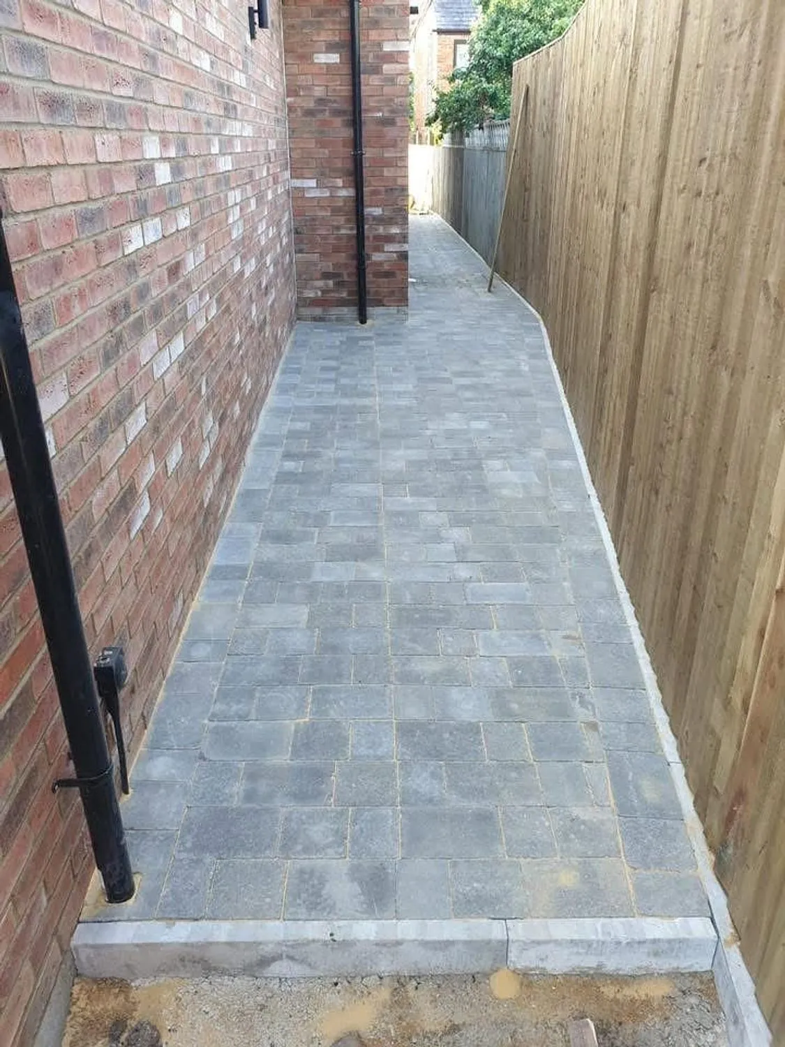 Block paved side path running the length of a house