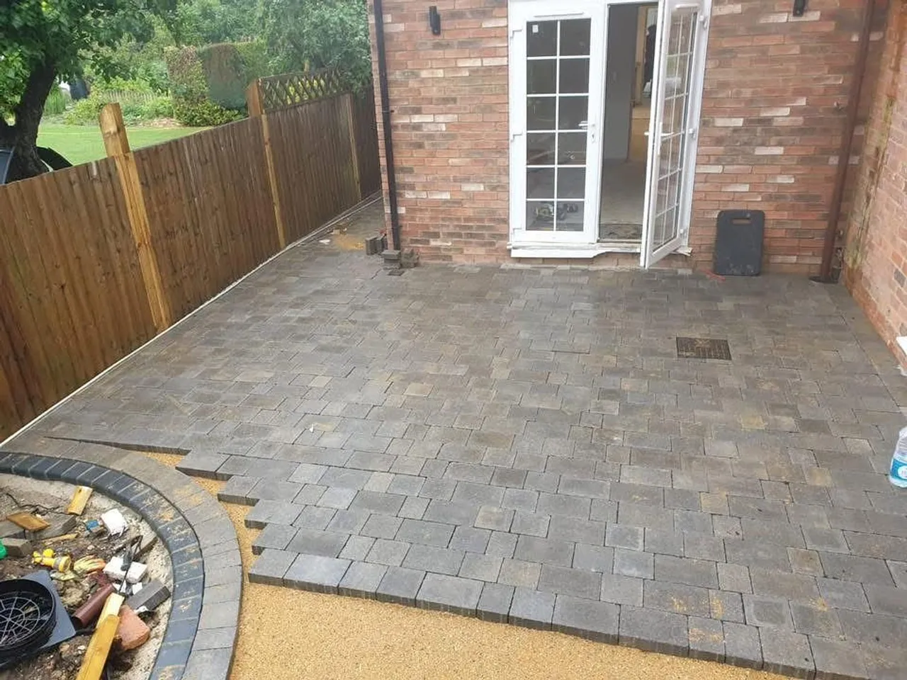 Block paved patio with a resin bound border laid at the rear of a house