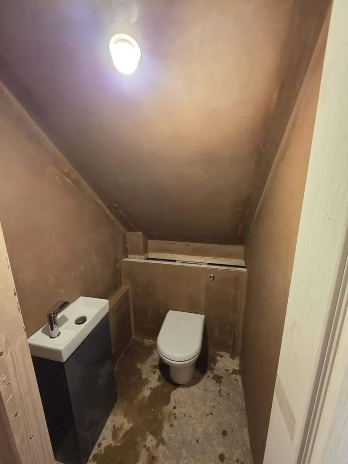 Cloakroom formed under the stairs, plastered with sanitaryware fitted