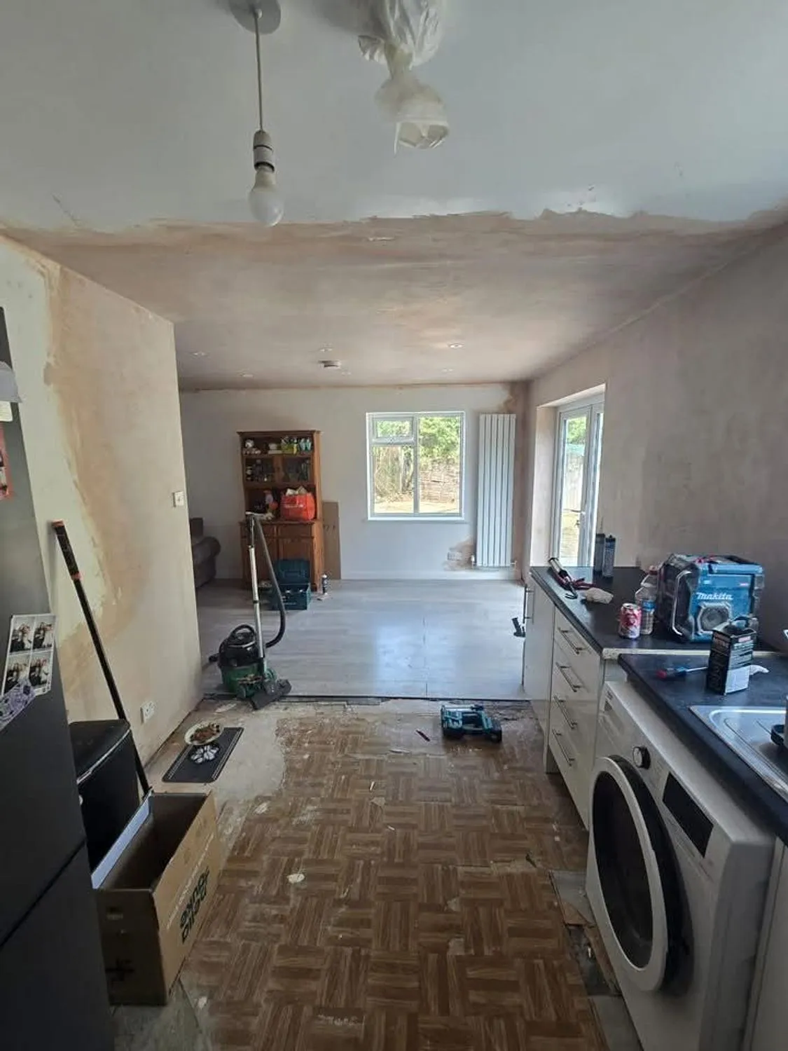 Open plan kitchen and dining space during a full renovation, freshly plastered