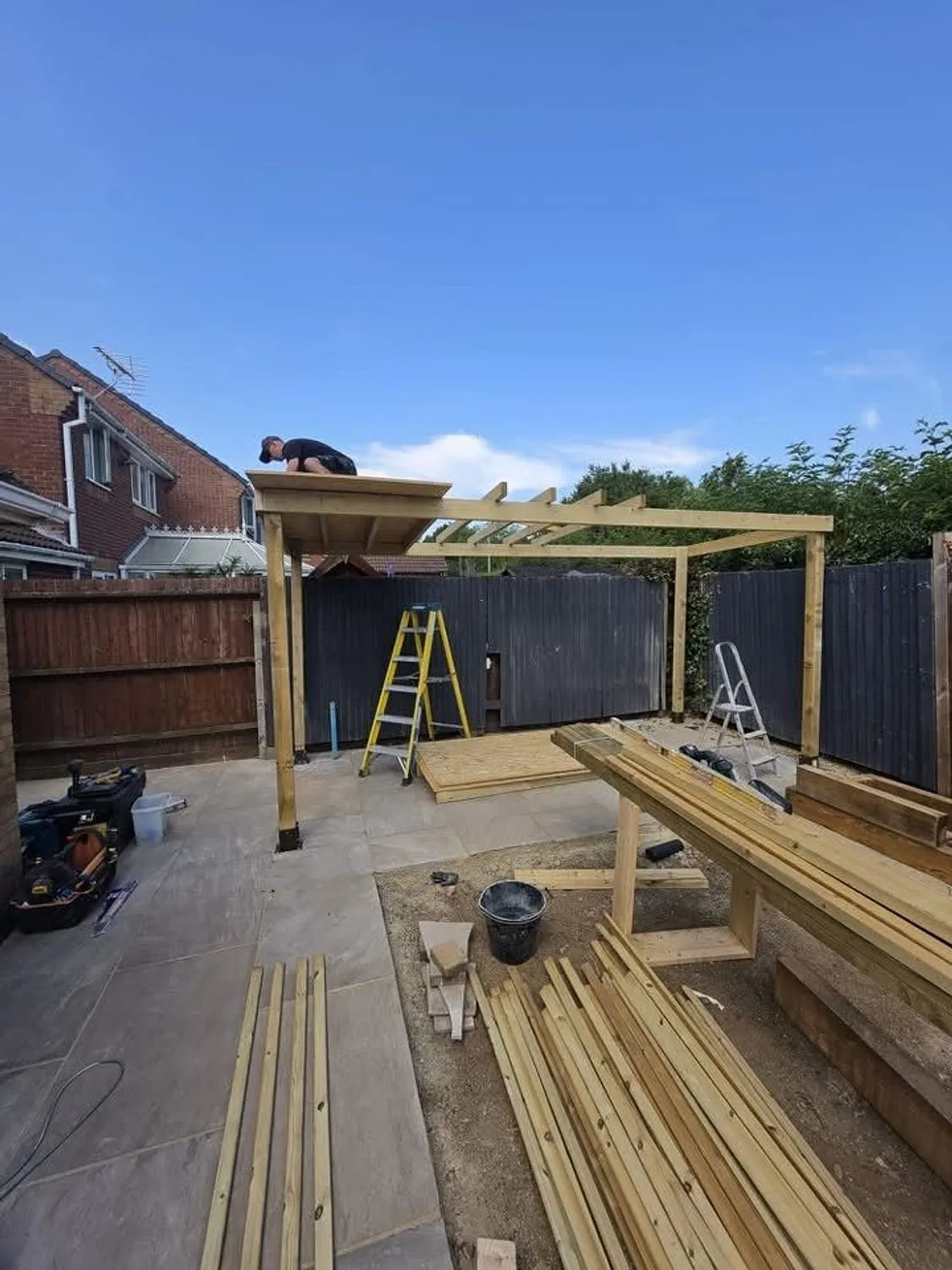 Timber frame for a garden structure going up over a new patio