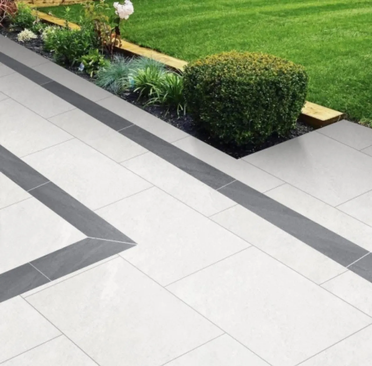 Porcelain paving with a contrasting border, box planting and a sleeper edged bed