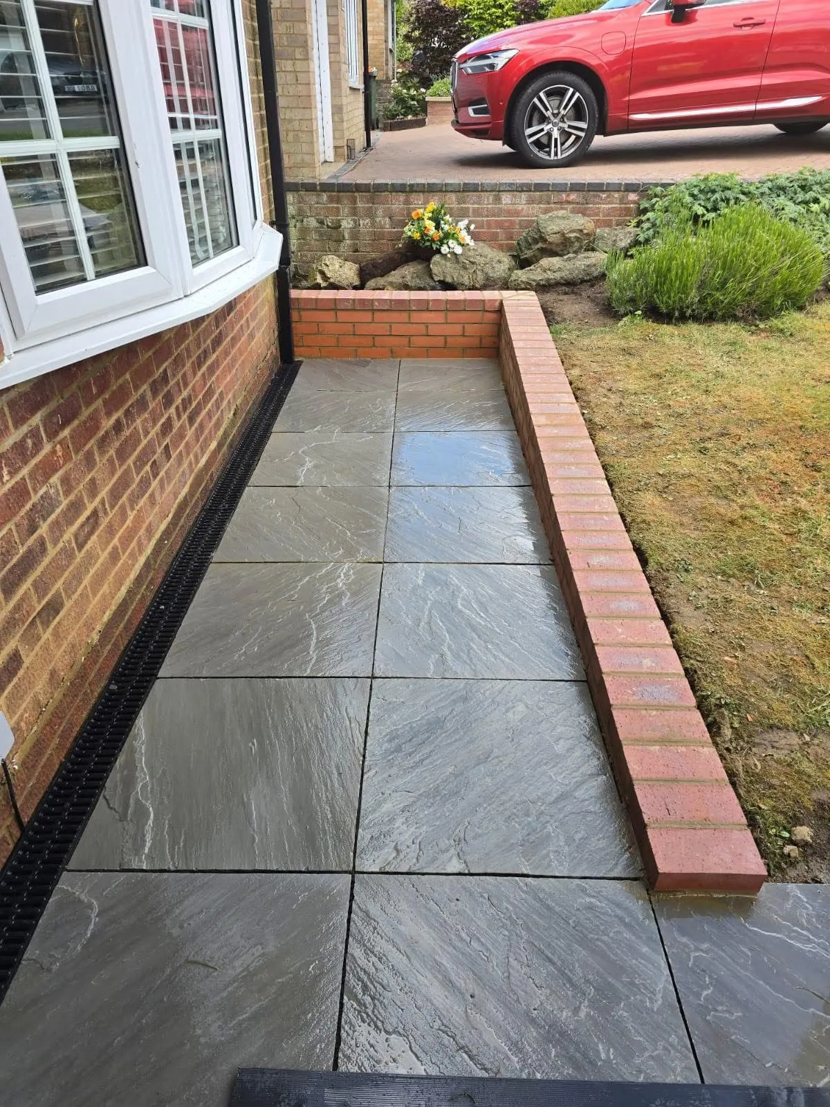New slate paving laid along a side path with a brick edge