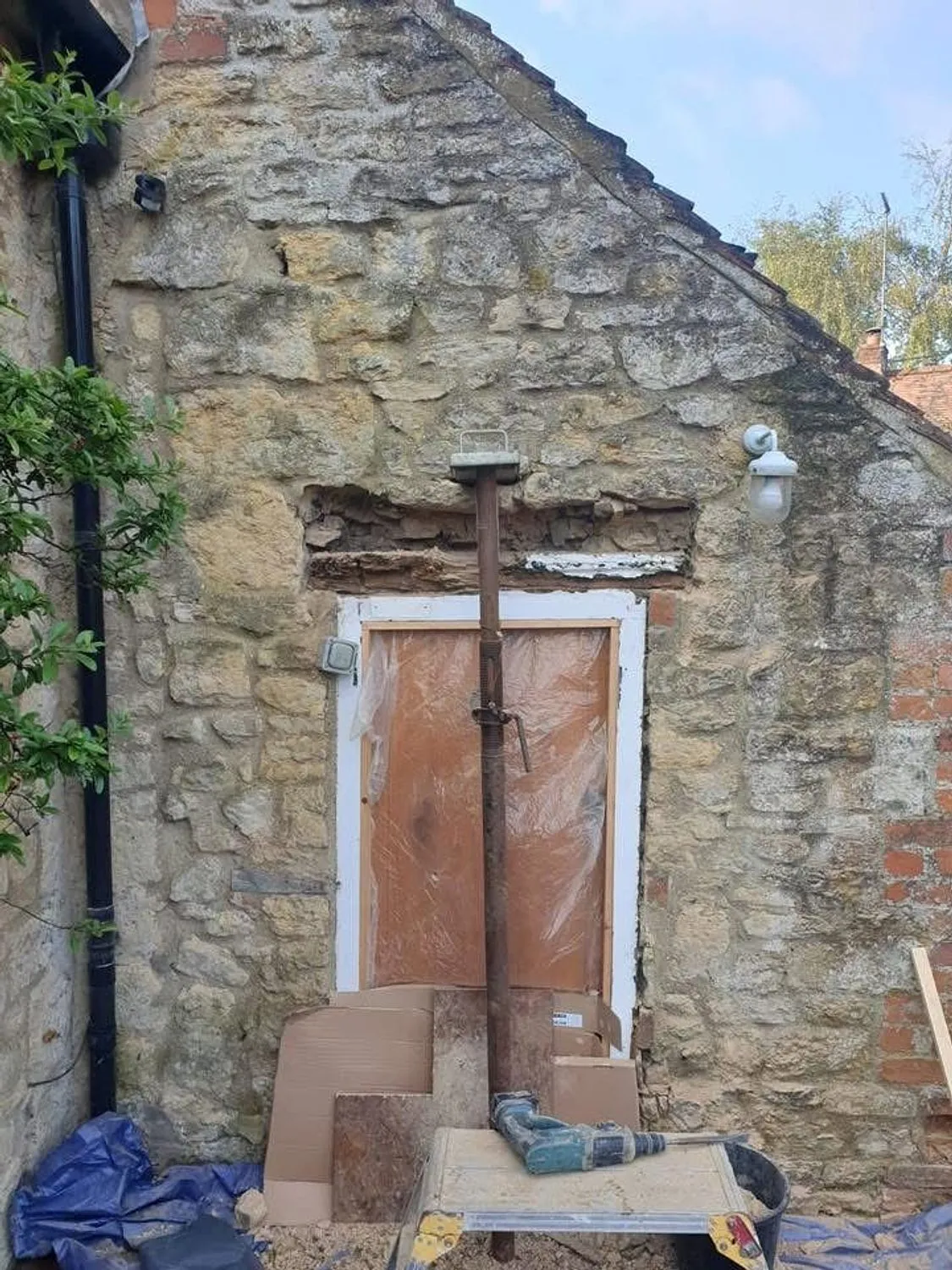 Doorway in a stone cottage propped and stripped back before structural repair