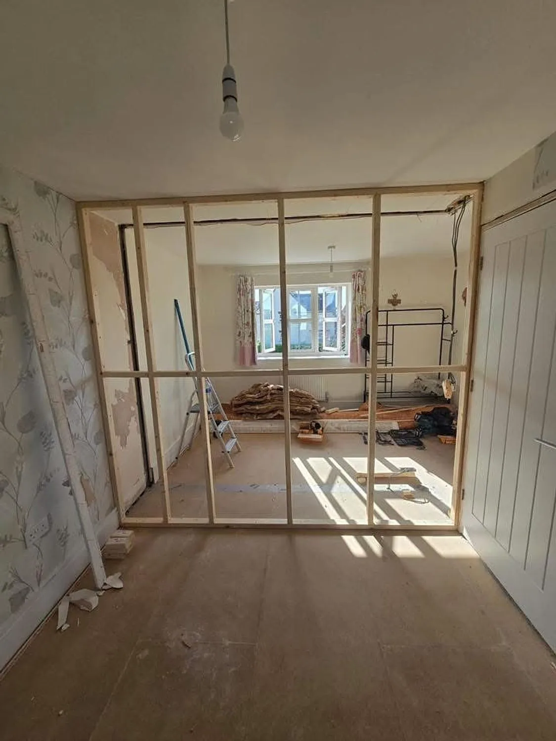 New stud partition framed out across a ground floor room