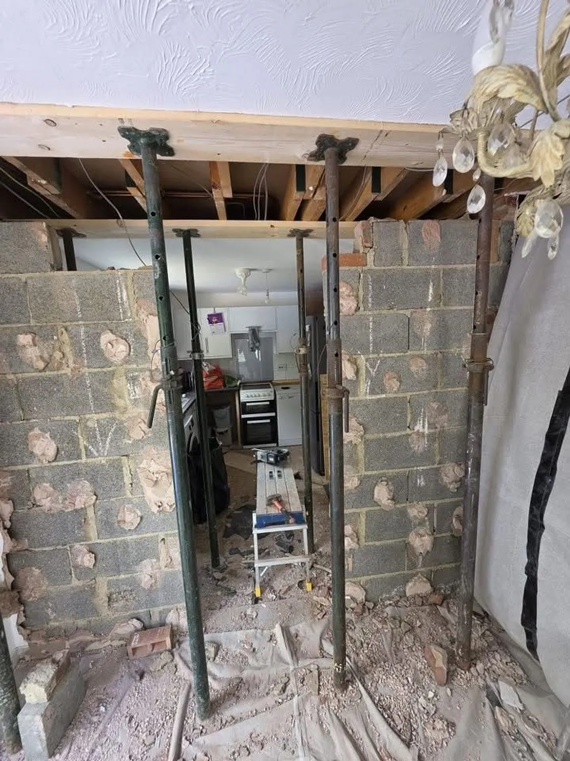 Load bearing wall removed with acrow props and strongboys supporting the floor above